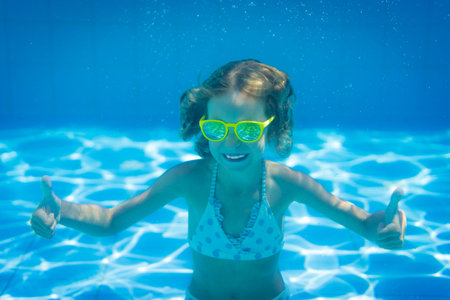 Underwater portrait of child. Kid having fun in swimming pool. Summer vacation conceptの写真素材