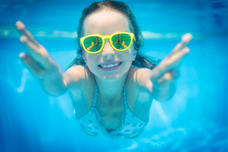 Underwater portrait of child. Kid having fun in swimming pool. Summer vacation conceptの写真素材