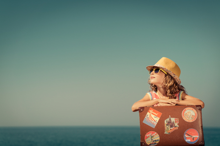 Happy child with vintage suitcase. Kid having fun on summer vacation. Travel and adventure conceptの写真素材