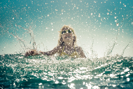 Happy child playing in the sea. Kid having fun at the beach. Summer vacation and active lifestyle conceptの写真素材