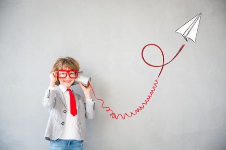 Portrait of young child pretend to be businessman. Kid playing at home. Success, idea, and creative concept. Copy space for your textの写真素材