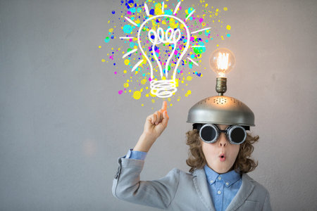 Portrait of child in classroom. Kid with toy virtual reality headset in class. Success, idea and...
