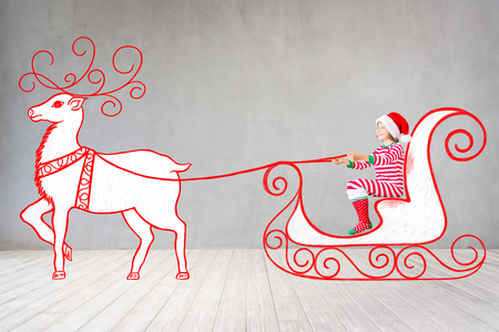 Happy child in Christmas time. Funny kid playing at home. Xmas winter holiday conceptの写真素材