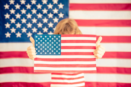 Child holding American flag. 4th of July, Independence day holiday. Patriotism and democracy conceptの写真素材