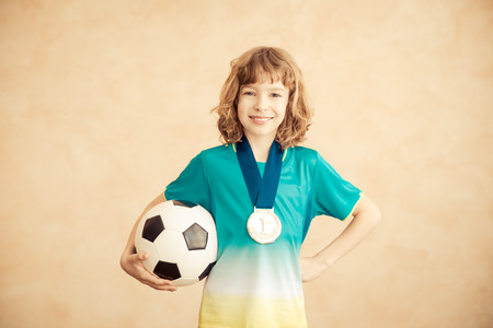 Child is pretending to be a soccer player. Success and winner conceptの写真素材