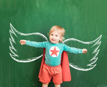 Happy child in class. Funny kid against chalkboard. Back to school. Education conceptの写真素材
