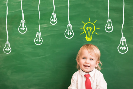 Happy child in class. Funny kid against chalkboard. Back to school. Education conceptの写真素材