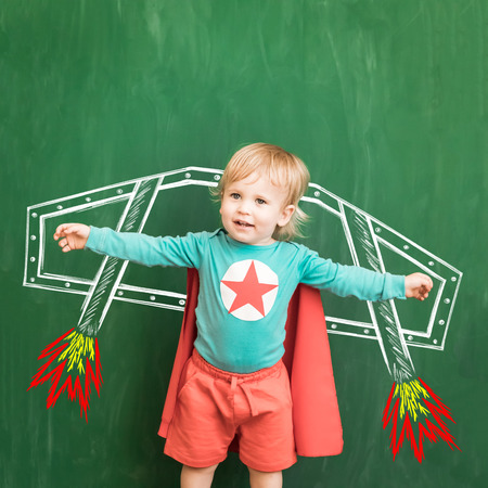 Happy child in class. Funny kid against chalkboard. Back to school. Education conceptの写真素材