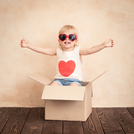 Happy child with red heart. Funny kid playing at home. Valentines day conceptの写真素材