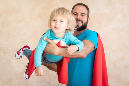 Man and child super hero at home. Superhero father and son having fun together. Family holiday concept. Happy Father's dayの写真素材