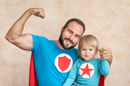 Man and child super hero at home. Superhero father and son having fun together. Family holiday concept. Happy Father's dayの写真素材