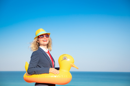 Successful businesswoman having fun on the beach. Young woman against sea and sky background. Summer vacations and freedom travel conceptの写真素材