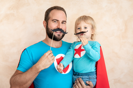 Man and child super hero at home. Superhero father and son having fun together. Family holiday concept. Happy Father's dayの写真素材