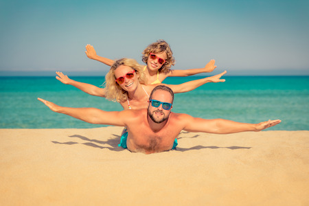 Happy family on summer vacation. People having fun on the beach. Active healthy lifestyleの写真素材