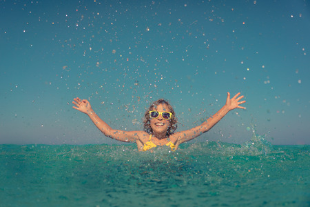 Happy child playing in the sea. Kid having fun on summer vacation. Healthy active lifestyle conceptの写真素材