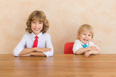 Happy children pretend to be businessmen. Funny kids playing at home. Education, start up and business idea conceptの写真素材