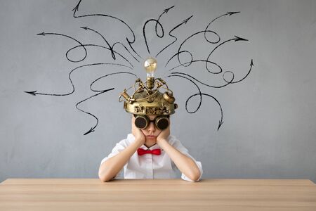 Portrait of child in classroom. Kid with toy virtual reality headset in class. Education, idea and innovation technology concept. Back to schoolの写真素材