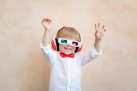 Funny kid wearing 3d glasses. Happy child having fun at home. Retro cinema concept