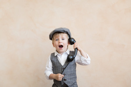 Happy child pretend to be businessmen. Funny kid talking by phone. Business negotiations concept