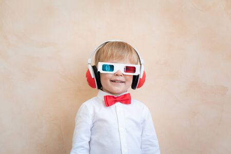Funny kid wearing 3d glasses. Happy child having fun at home. Retro cinema conceptの写真素材
