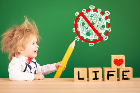 Child drawing sign stop coronavirus covid-19. Happy kid against green chalkboard. Safe life concept....