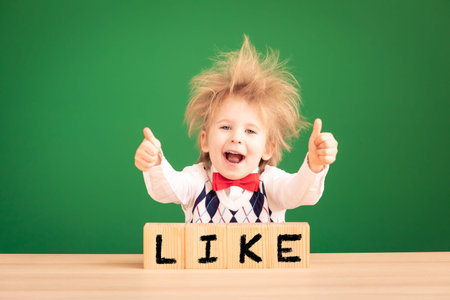 Bright idea! Funny child student in class. Happy kid against green chalkboard. Online education and...