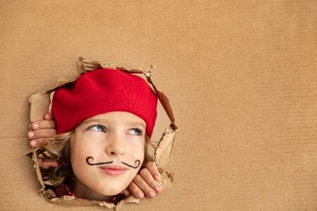 Artist child holding banner blank. Happy kid pretend to be painter. Imagination and childhood dream conceptの写真素材