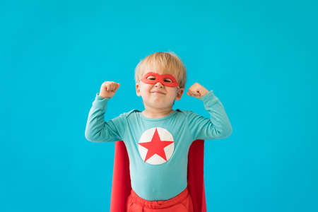 Portrait of superhero child. Super hero kid against blue background. Success and winner conceptの写真素材