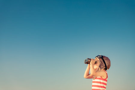 Child look through marine glasses. Kid having fun outdoor. Summer vacation and travel conceptの写真素材