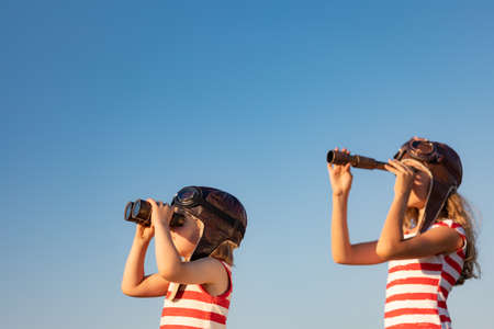 Children playing against summer sky background. Kids having fun outdoor. Summer vacation and travel conceptの写真素材