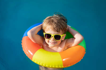 Happy child swimming in pool. Kid having fun on summer vacation. Healthy lifestyle conceptの写真素材