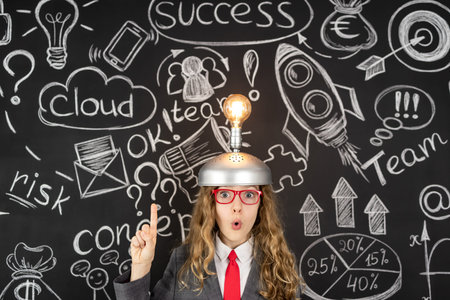 Young businesswoman against chalkboard with business sketch. Success marketing plan and startup...