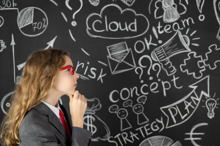 Young businesswoman against chalkboard with business sketch. Success marketing plan and startup conceptの写真素材