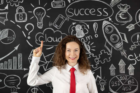 Successful young businesswoman in the office. Woman standing against blackboard. Success business and startup conceptの写真素材