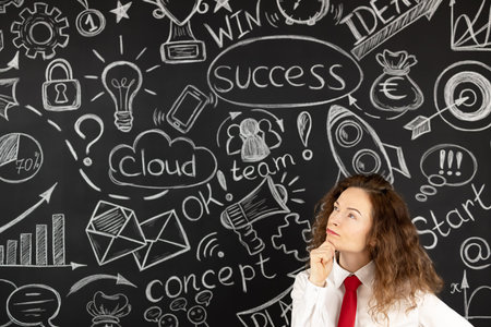 Successful young businesswoman in the office. Woman standing against blackboard. Success business...