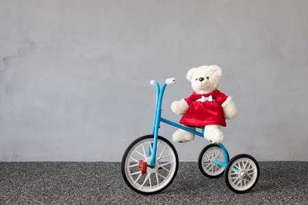 Teddy bear wearing Christmas costume sitting on vintage tricycle. Xmas holiday conceptの写真素材
