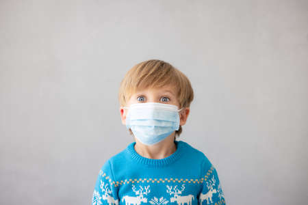 Portrait of child wearing medical mask. Christmas holiday during coronavirus covid-19 pandemic conceptの写真素材