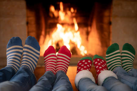 Family in Christmas socks near fireplace. Mother; father and children having fun together. People relaxing at home. Winter holiday Xmas and New Year conceptの写真素材