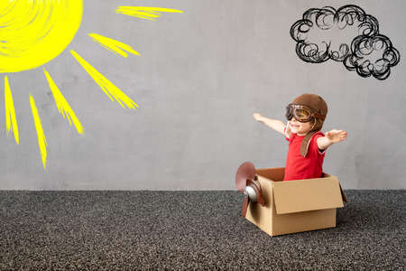 Child pretend to be pilot. Kid having fun at home. Children imagination. Kid dreaming about travel. Summer vacation and travel conceptの写真素材