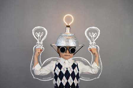 Smart child pretend to be businessman. Funny kid wearing helmet with lightbulb. Education, start up...