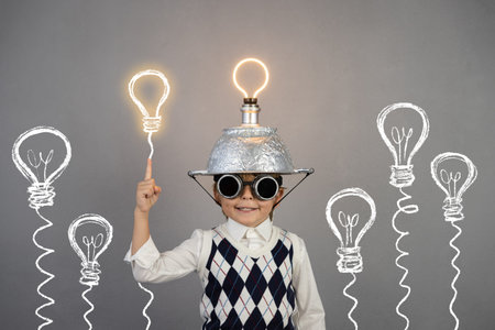Smart child pretend to be businessman. Funny kid wearing helmet with lightbulb. Education, start up...