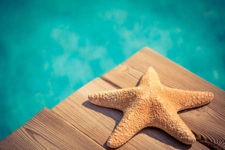 Starfish on wood against blue water background. Summer vacation conceptの写真素材