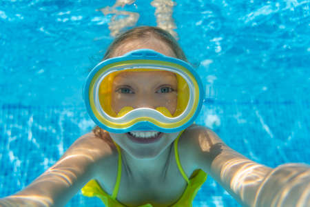 Underwater portrait of child. Kid having fun in swimming pool. Summer vacation conceptの写真素材