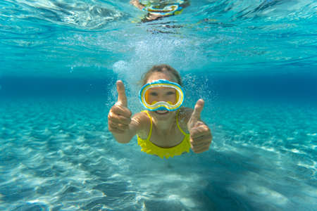 Underwater portrait of child. Kid having fun in the sea. Summer vacation and healthy lifestyle conceptの写真素材