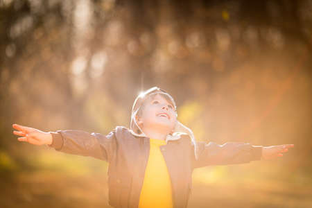 Portrait of happy child wearing pilot costume against yellow leaves background. Smiling kid having fun outdoor in autumn park. Freedom and imagination conceptの写真素材