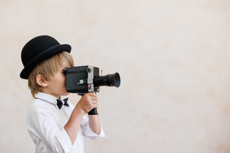 Newsboy shouting against grunge wall background. Kid selling newspaper. Child wearing vintage costume. Social media and Internet nerwork conceptの写真素材