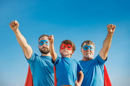 Senior, man and child outdoor against summer blue sky. Grandfather, father and son pretend to be superheroes. People having fun together. Family vacation and holiday concept. happy father's dayの写真素材