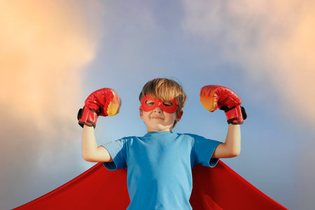 Superhero child against summer blue sky. Super hero boy having fun outddor. healthy lifestyle conceptの写真素材