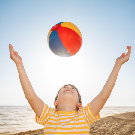 Happy child on summer holiday. Kid having fun on the beach. boy playing with beach ball. Summer vacation and travel conceptの写真素材