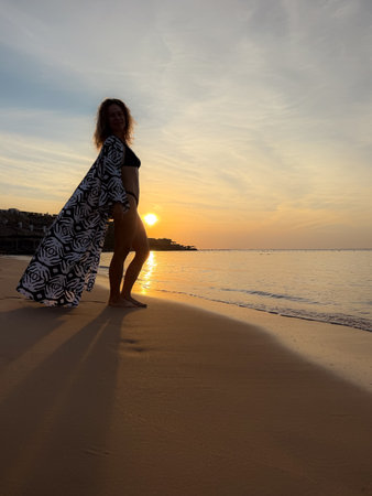 Silhouette of young woman relaxing at the sandy beach. Summer vacations conceptの写真素材